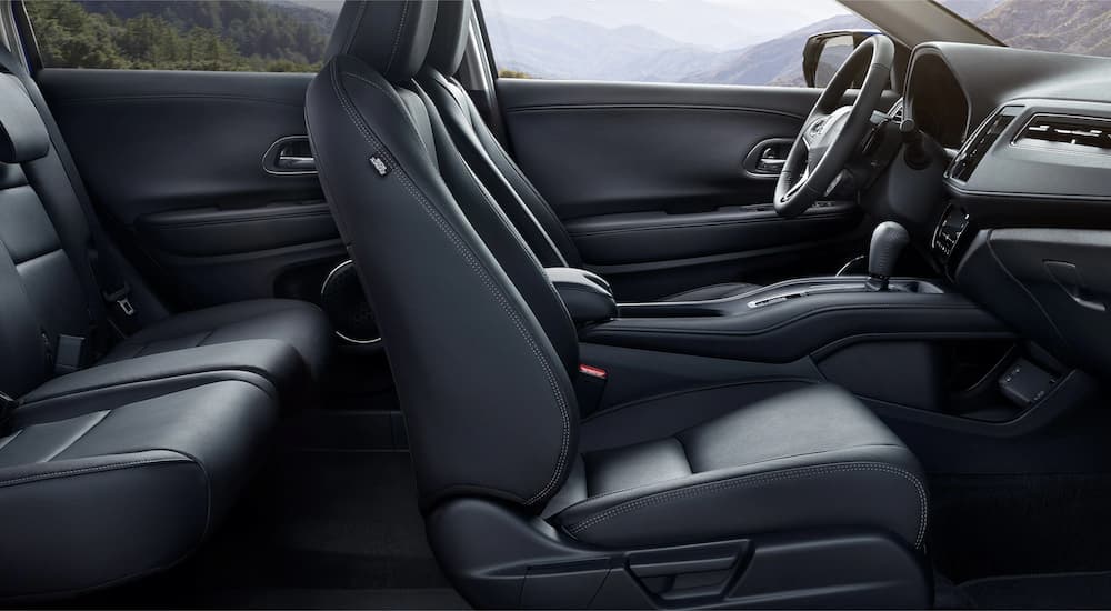 The black leather interior of a 2022 Honda HR-V EX-L shows two rows of seating from the side.