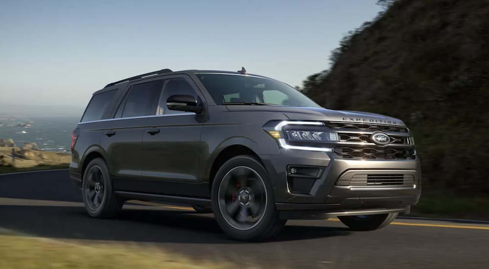 A grey 2022 Ford Expedition is shown from the side driving on an open road.