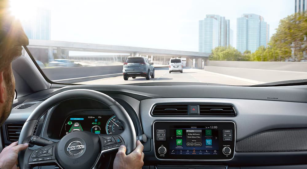 A person is shown driving a 2022 Nissan LEAF.
