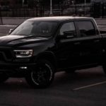 A black 2022 Ram 1500 is shown from the side parked in a parking lot.