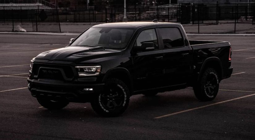 A black 2022 Ram 1500 is shown from the side parked in a parking lot.