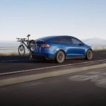 A blue 2022 Tesla Model X is shown from the rear with a bike mounted in the rear.
