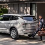 A man is shown opening the rear liftgate of a silver 2022 Buick Enclave.