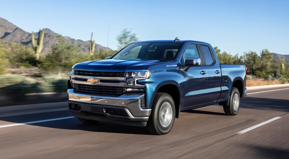 A blue 2019 Chevy Silverado 1500 is shown driving on a highway.