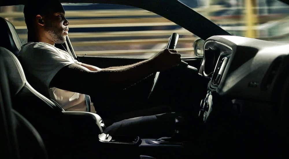 A person is shown driving a 2020 Dodge Charger.