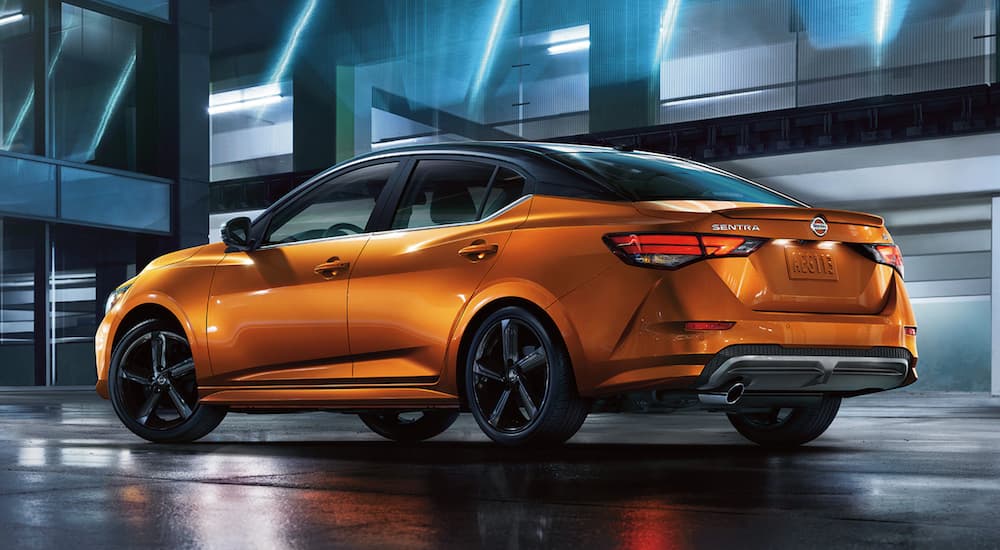 An orange 2021 Nissan Sentra is shown from the side parked in a modern gallery.