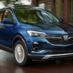 A blue 2022 Buick Encore GX is shown from the side driving on an open road.