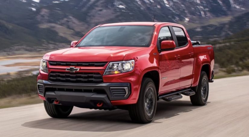 A red 2022 Chevy Colorado Trail Boss is shown from the front driving on an open road.