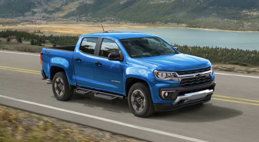 A blue 2022 Chevy Colorado is shown from the side driving on an open road. 