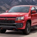 A red 2022 Chevy Colorado is shown from the front driving on an open road.