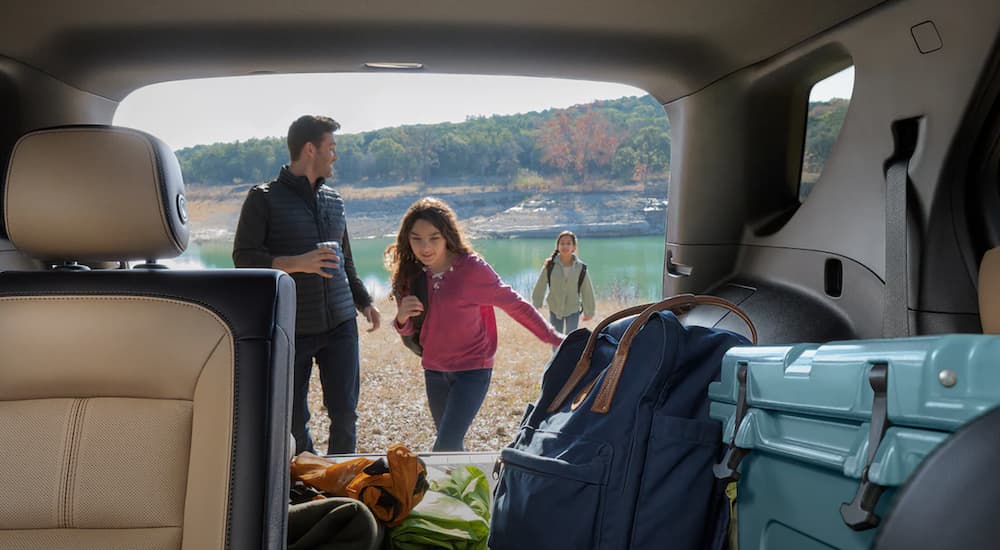 A family is shown putting gear into the rear cargo space of a 2022 Chevy Equinox at the beach.