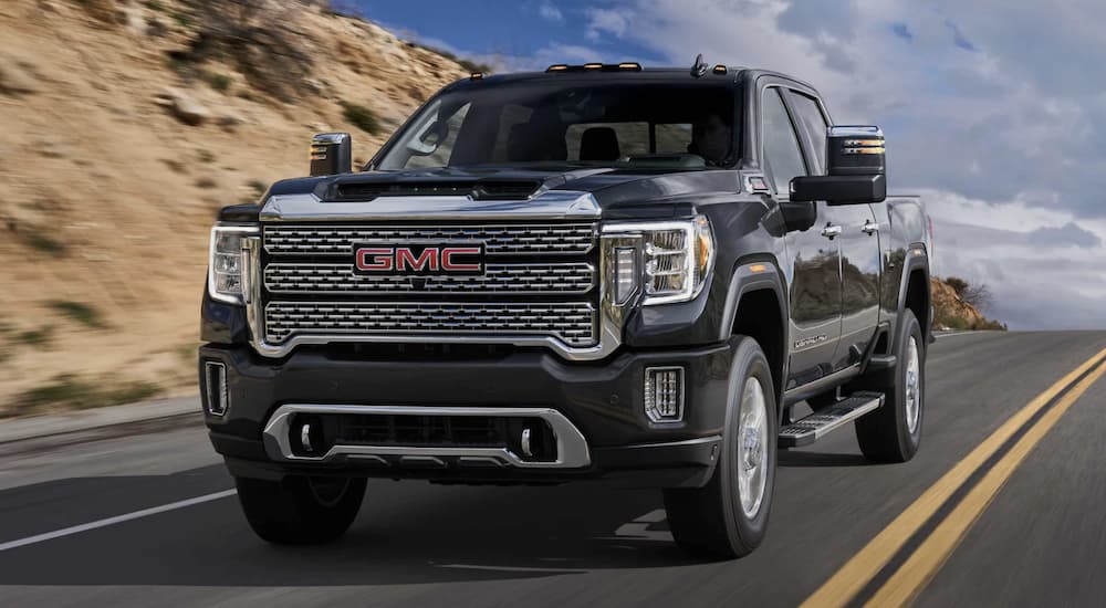 A black 2022 GMC Sierra 3500HD is shown from the front driving on an open road.