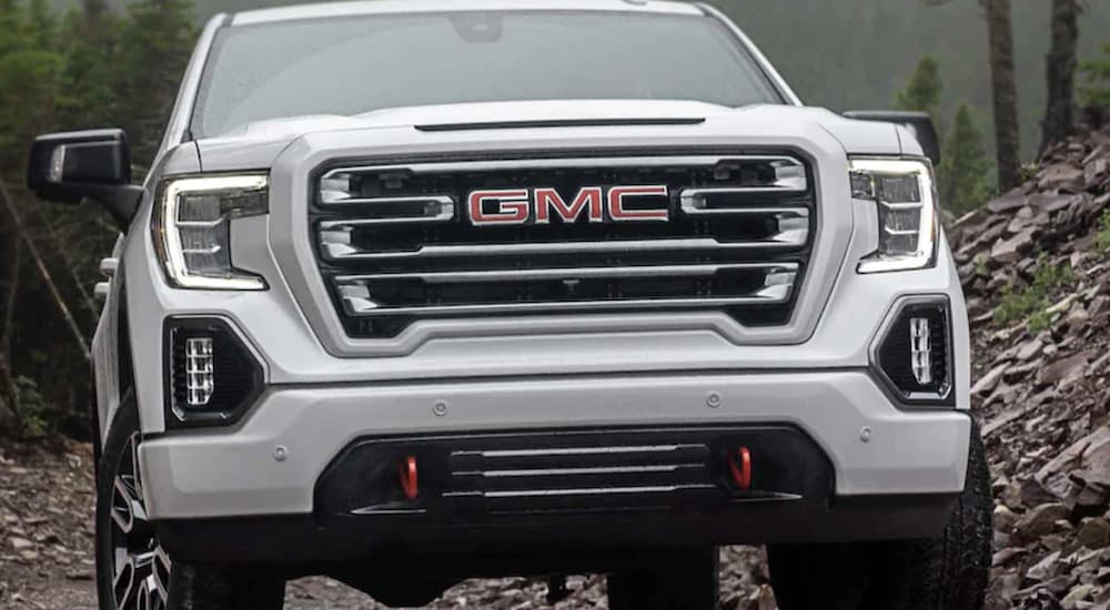 A white 2022 GMC Sierra 1500 is shown from the front off-roading.