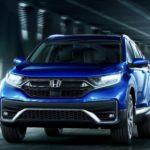 A blue 2022 Honda CR-V Hybrid Touring is shown from the front driving through a tunnel.