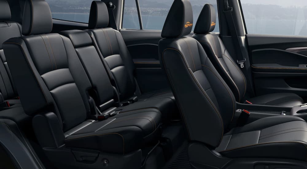 The black interior or a 2022 Honda Pilot TrailSport shows the rows of seating.