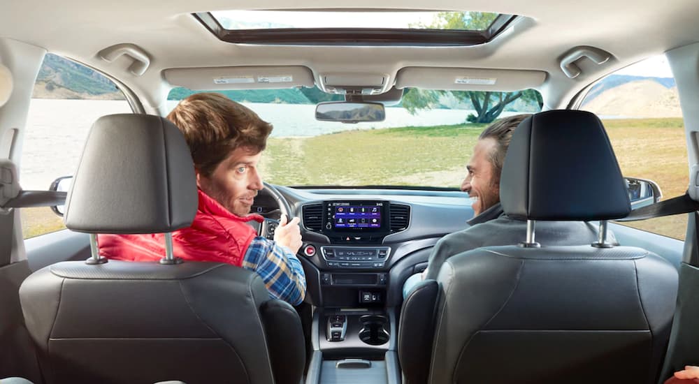 Two people are shown in the interior of a 2022 Honda Ridgeline RTL-E.