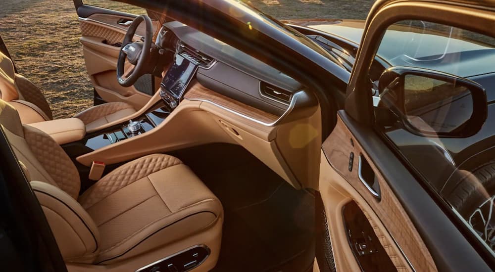The tan and brown interior of a 2022 Jeep Grand Cherokee L shows the front seats.