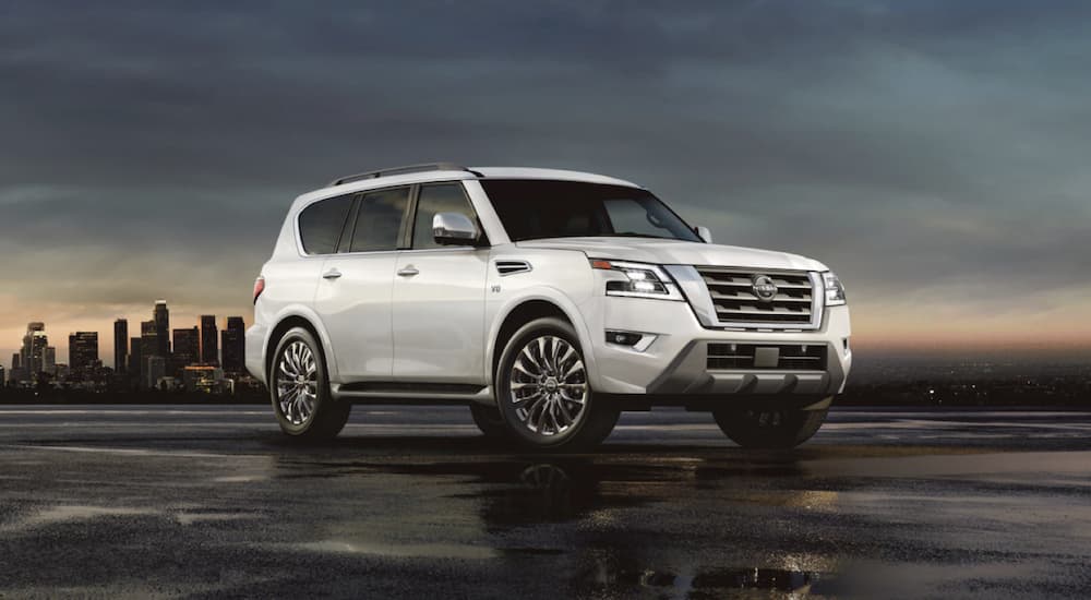 A white 2022 Nissan Armada is shown from the side parked in front of a city after winning a 2022 Nissan Armada vs 2022 Toyota Sequoia comparison.