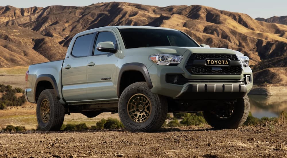 A soft green 2022 Toyota Tacoma SR5 Double Cab is shown parked in the mountains.