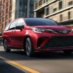 A red 2022 Toyota Sienna XSE is shown from the front driving through a city.