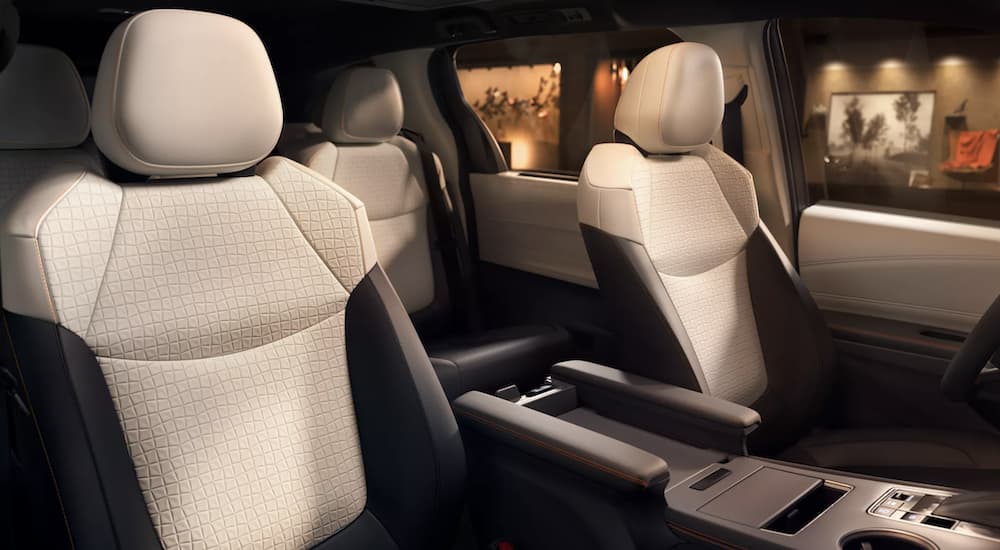 The white interior of a 2022 Toyota Sienna XSE shows two rows of seating.