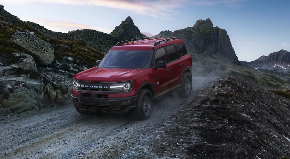 A red 2021 Ford Bronco Sport is shown driving down a rocky path.