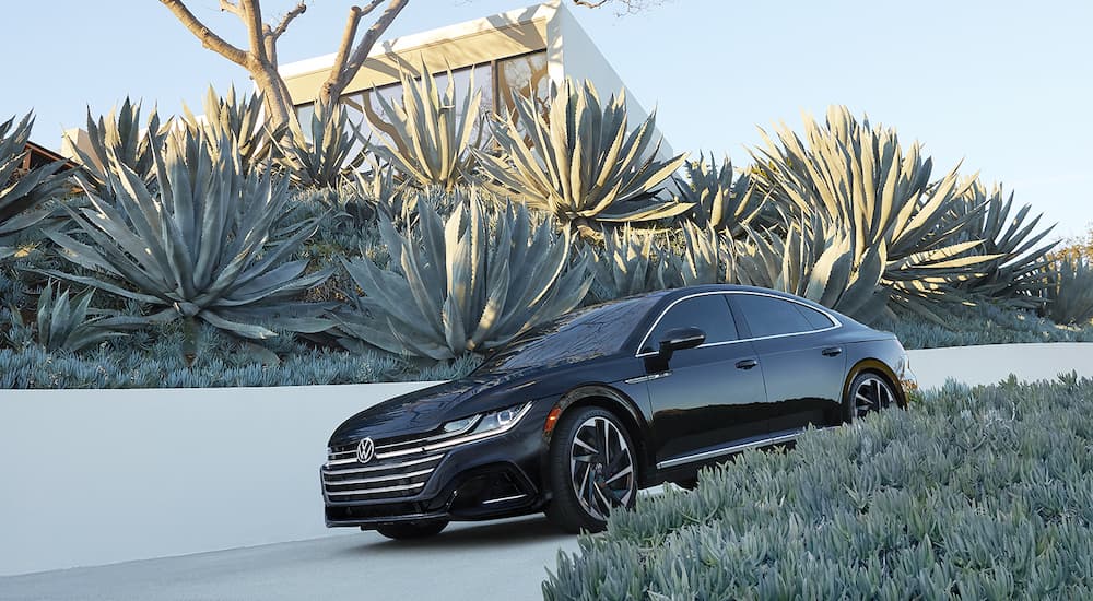 A black 2022 Volkswagen Arteon is shown parked in a driveway.