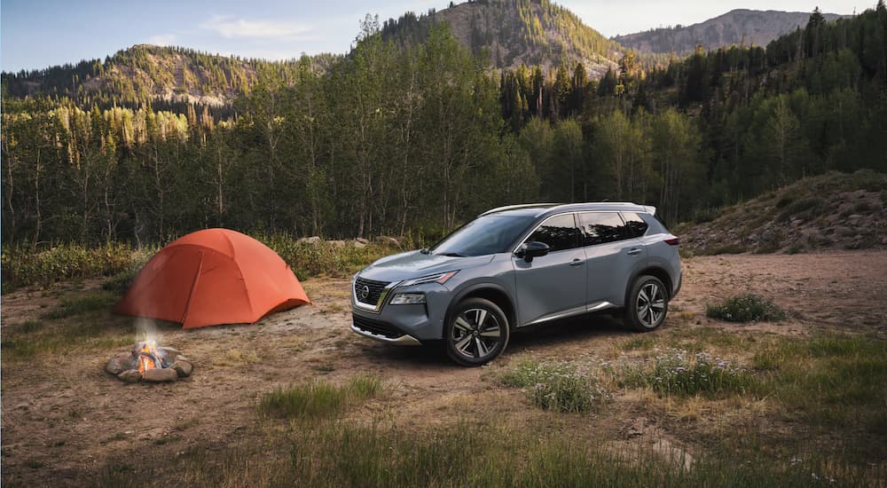 A silver 2021 Nissan Rogue is shown parked at a campsite.