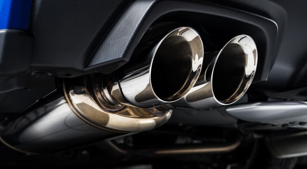 A close up shows a silver car exhaust.