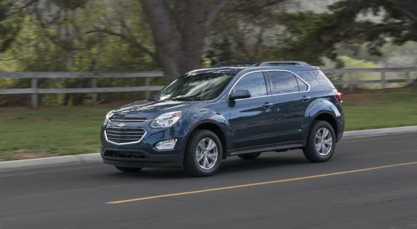 A blue 2016 Chevy Equinox is shown from the side driving on an open road after leaving a Certified Pre-Owned Chevy dealer.