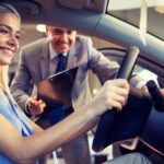 A woman and salesmen are shown testing out a Certified Pre-Owned Honda.