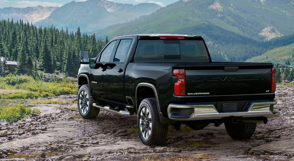 A black 2022 Chevy Silverado 1500 LT is shown from a rear angle in the mountains.