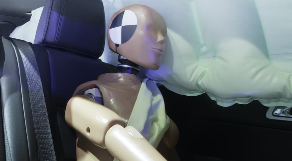An automotive crash test dummy is strapped into car seat during a side crash.