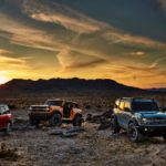 Three 2021 Ford Broncos are shown parked in the desert after leaving a Ford Bronco dealer.