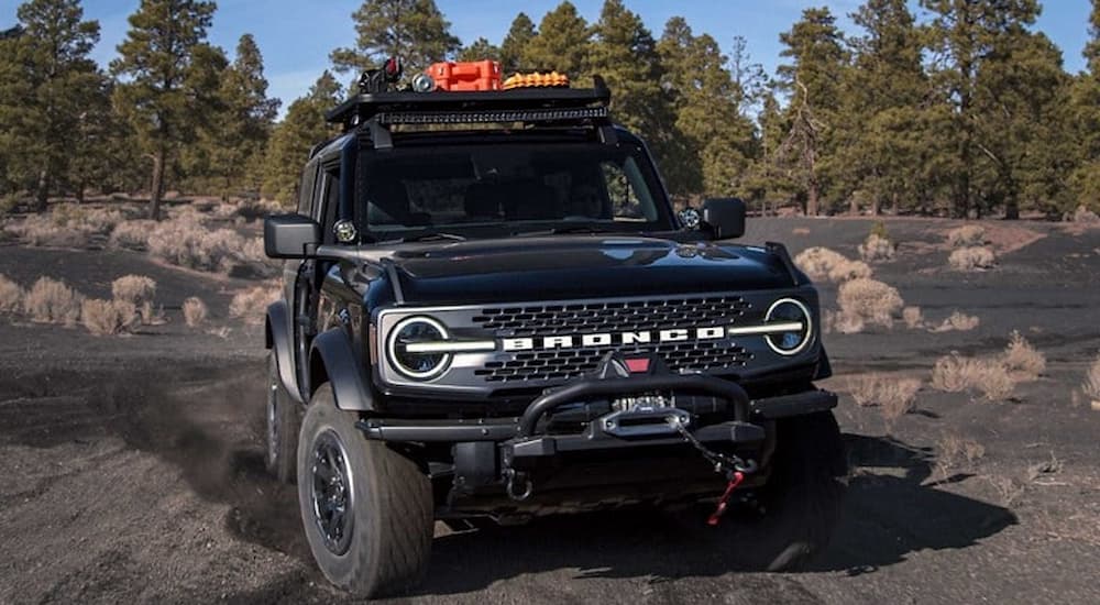 A black 2021 Ford Bronco WildTrak is shown off-roading.