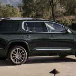 A black 2022 GMC Acadia Denali is shown from the side parked in a driveway after leaving a GMC Acadia dealer.