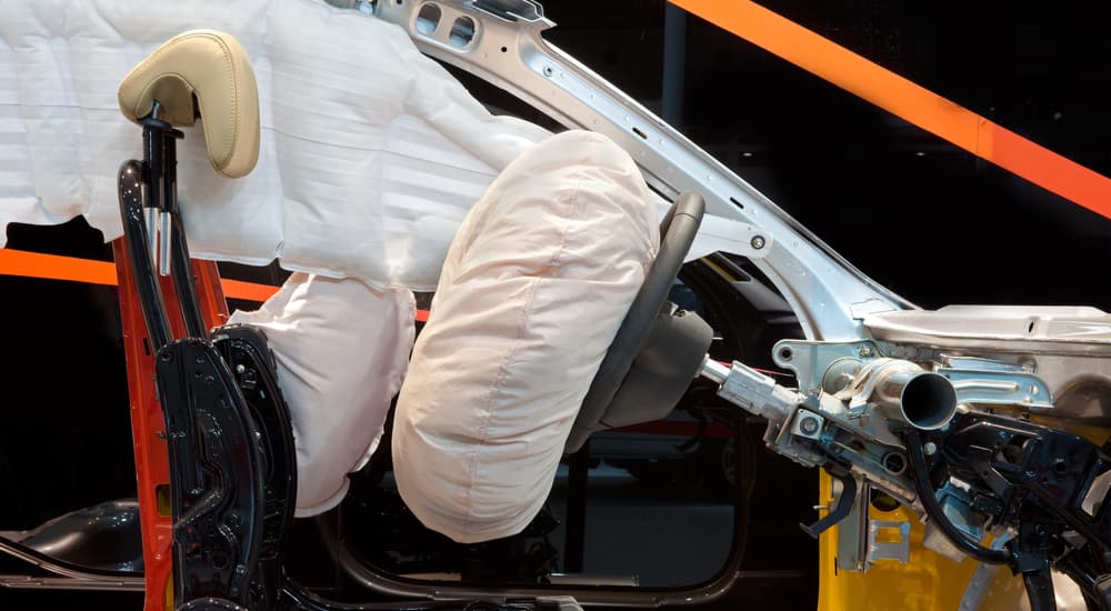 A car is shown with the airbags deployed.
