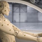 A crash testing dummy is shown in the front seat of a car.