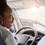 A person is shown in the drivers seat of a car after searching 'how to sell your car.'