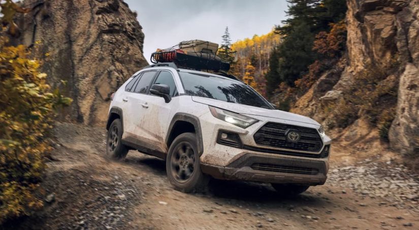 A white 2022 Toyota RAV4 TRD is shown from the front off-roading in the mountains after leaving a Toyota dealer.