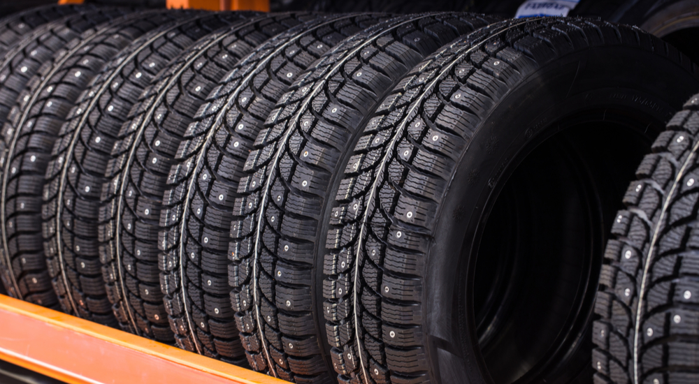 A set of studded winter tires near you are shown on a rack.