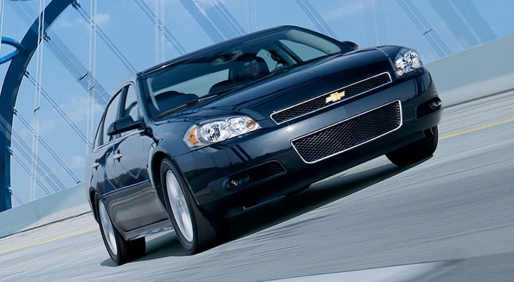 A black 2012 Chevy Impala is shown from the front driving over a bridge.
