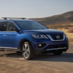 A blue 2017 Nissan Pathfinder is shown from the side off-roading in a desert after leaving a used Nissan dealership.