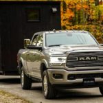 A silver 2019 Ram 2500 is shown from the front towing a closed trailer after leaving a used truck dealer.