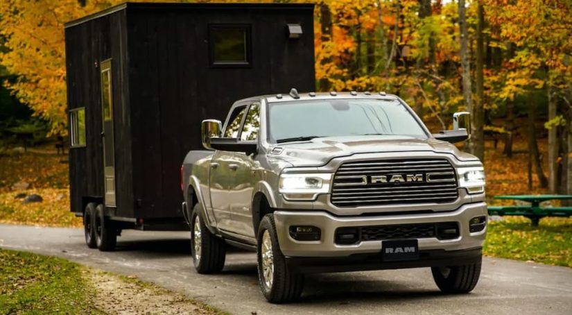 A silver 2019 Ram 2500 is shown from the front towing a closed trailer after leaving a used truck dealer.