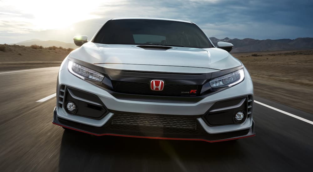 A white 2021 Honda Civic Type R is shown from the front driving on a highway.