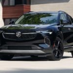 A black 2022 Buick Envision is shown parked outside of a modern home.