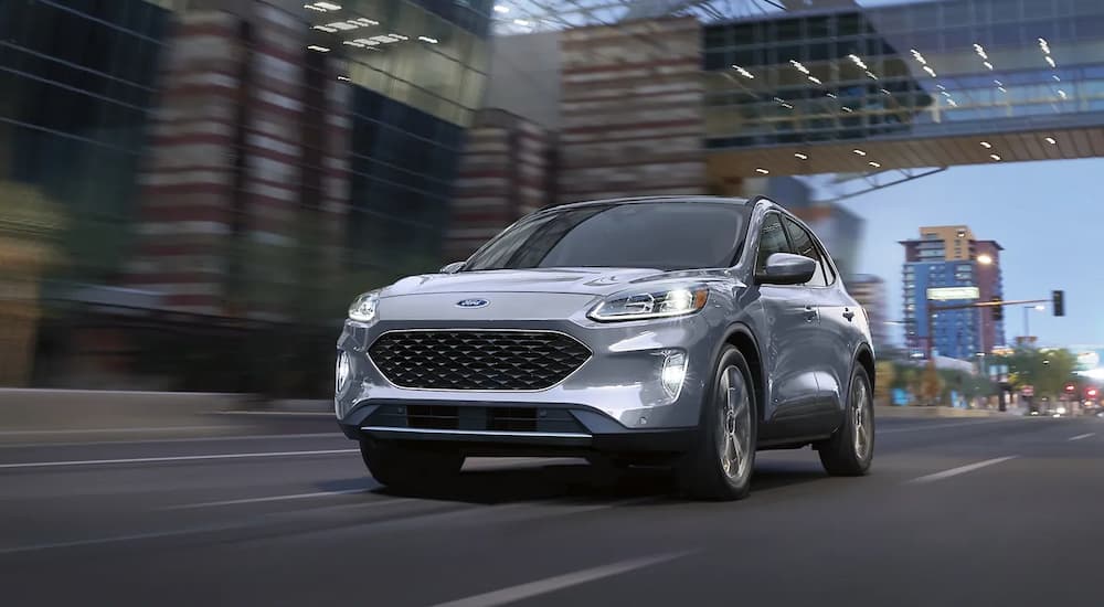 A silver 2022 Ford Escape Titanium Hybrid is shown on a city highway during a 2022 Buick Envision vs 2022 Ford Escape competition.