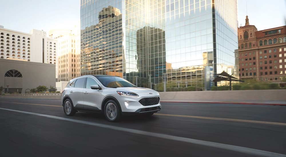A white 2022 Ford Escape SE is shown driving on a city street.