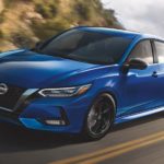 A blue 2022 Nissan Sentra is shown on a highway during a 2022 Nissan Sentra vs the 2022 Honda Civic comparison.